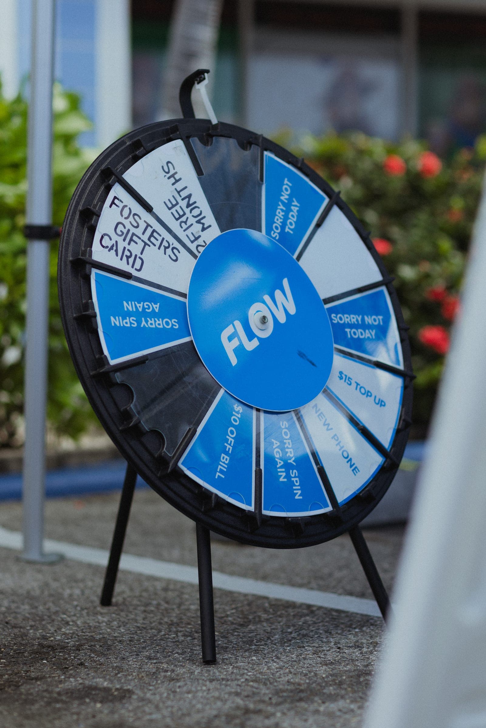 A blue and white Flow prize wheel on a stand outside the store