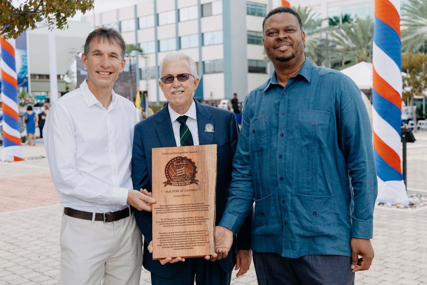 Flow leaders holding the Builder of Cayman award at the National Heroes Day ceremony