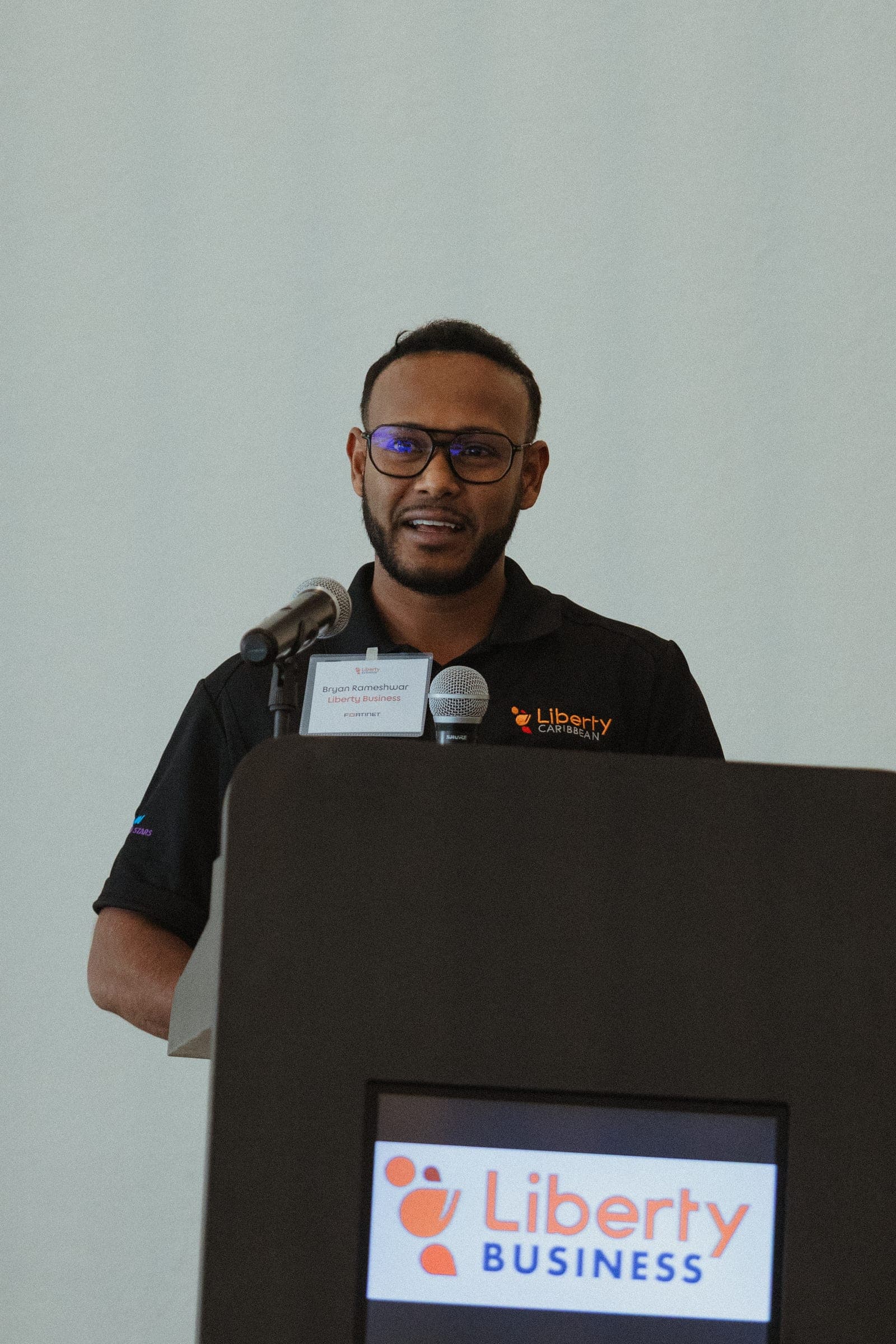 A Liberty Business speaker addresses guests from a branded podium