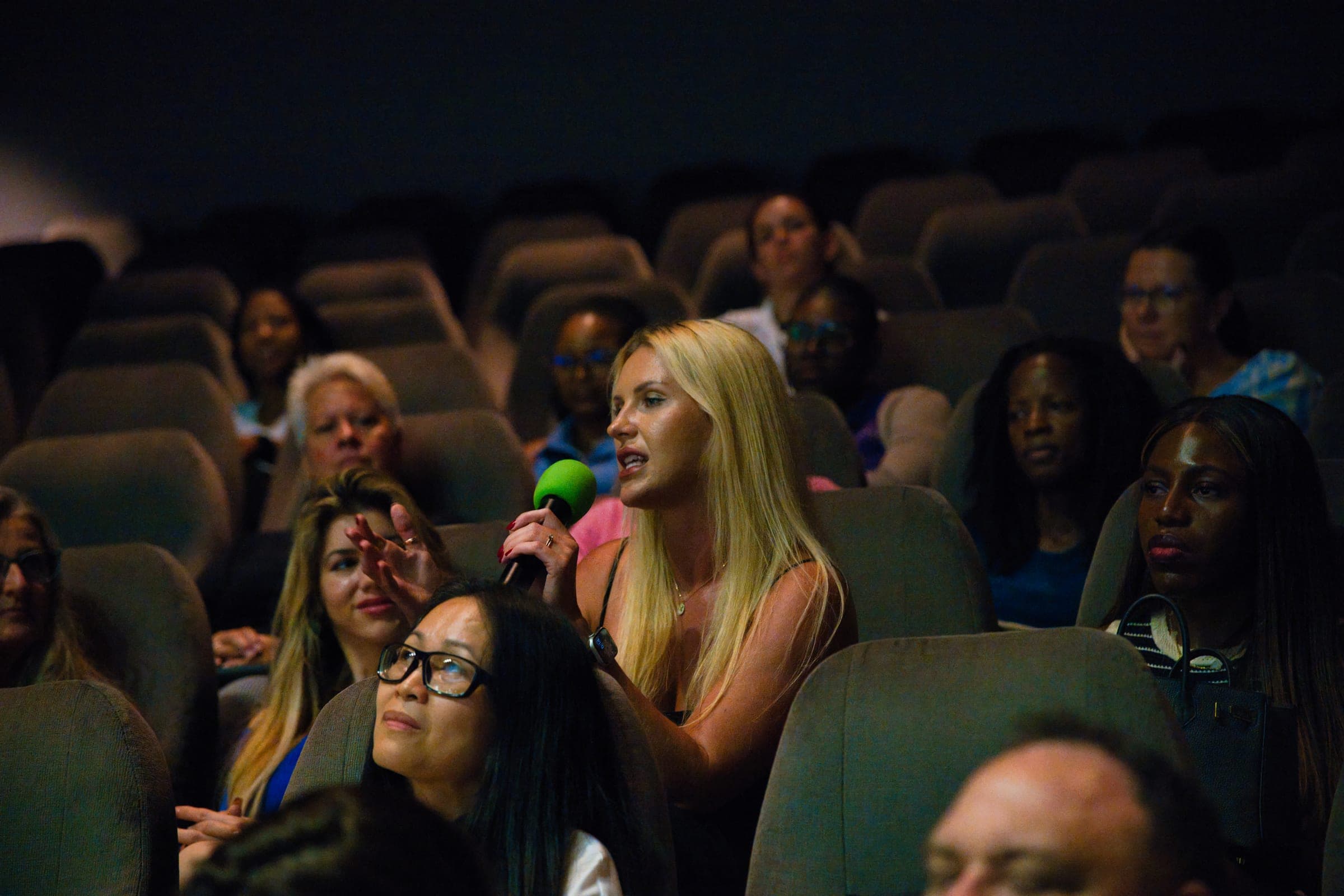 An audience member asks the panel a question in the Camana Bay cinema